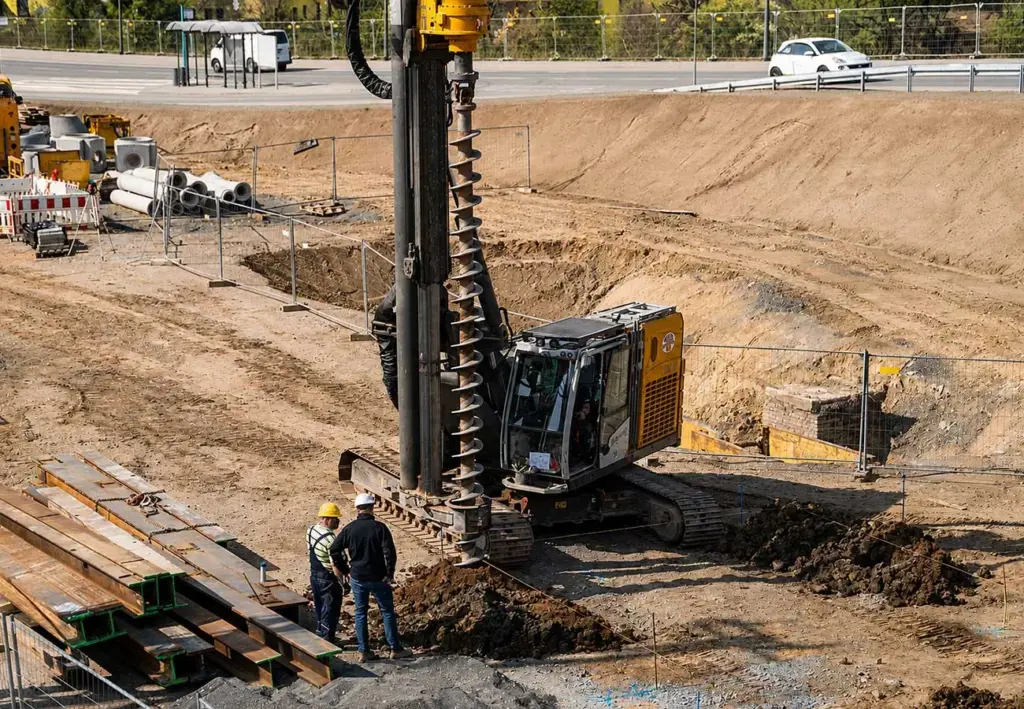 Bagger und Mitarbeitende auf einer Baustelle