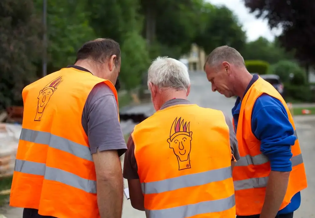 Drei Bauarbeiter besprechen den Arbeitsablauf auf der Baustelle